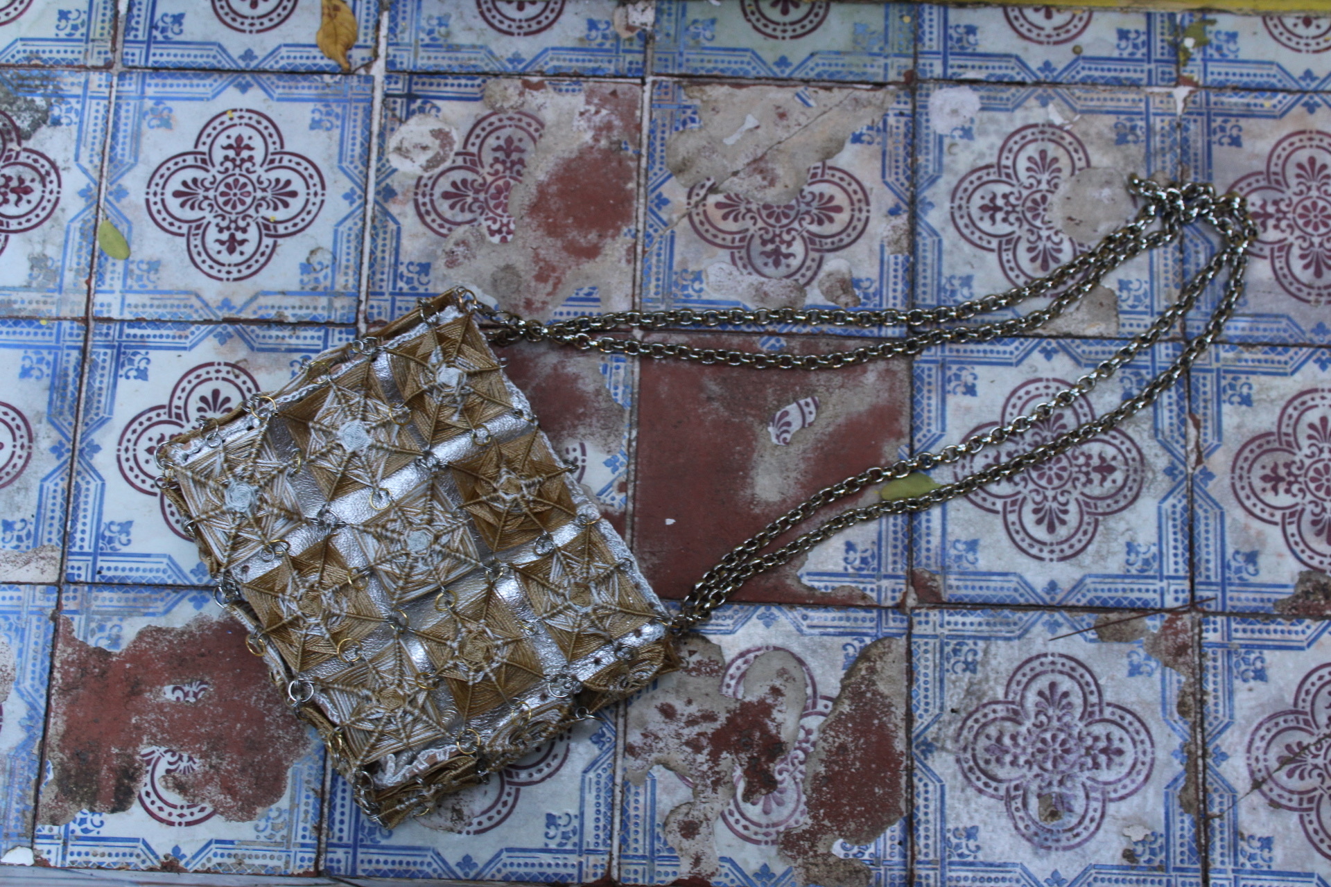 Gold and silver OCCHI FILO bag on Portuguese tiles
